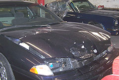 Car with damaged front waits in line at body shop