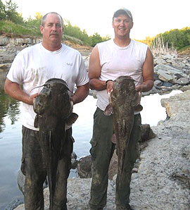 Conservation officers Jeff Swearngin abd Brandon Bregquist hold big catfish.