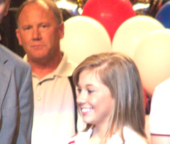 Doug Johnson watches as his daughter acknowledges cheers from the crowd.