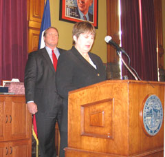 Governor Chet Culver watches as Iowa Workforce Development Director Elizabeth Buck speaks.