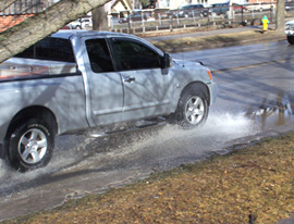 A truck drives through standing water in Des Moines caused by melting snow.