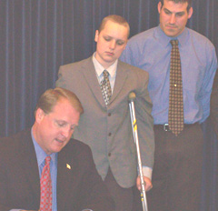 Governor Chet Culver signs bill as Drew Wall, Nick Ackerman watch.