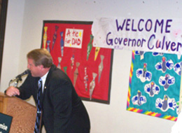 Governor Culver leans on podium to talk to preshoolers in Des Moines.