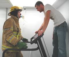 I.S.U. kinesiology research associate Hector Angus explains the physical testing procedures to firefighter Mike Hartman, captain of the Muscatine Fire Department.