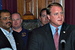 Representative Kerry Burt (far left)  listens to Governor Culver during an event at the capitol earlier this year.